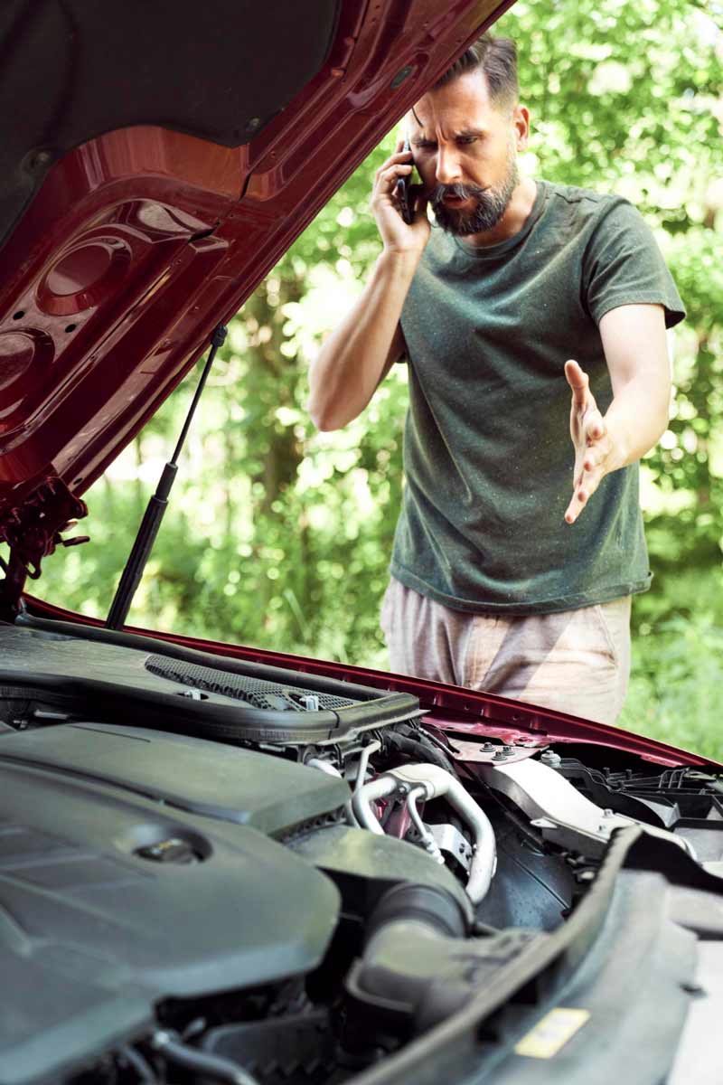 Junger Mann prüft Getriebeschaden bei Schrottauto Ankauf Rheinbach